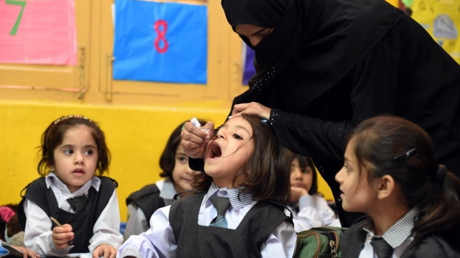 14.set.2015 - Profissional da saúde dá vacina contra pólio à criança em uma escola de Quetta, no Paquistão - Banaras Khan/AFP