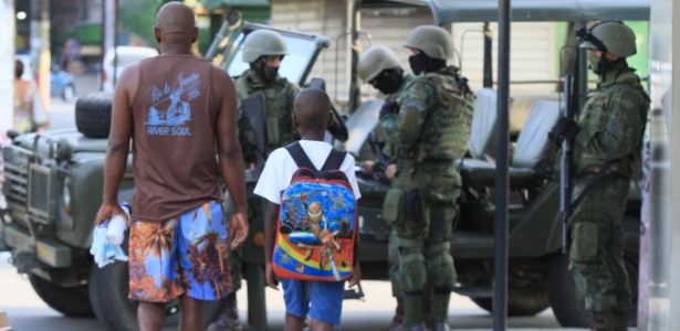 7.mar.2018 - Homem leva criança a escola em meio a operação das Forças Armadas - Jose Lucena/Futura Press/Estadão Conteúdo