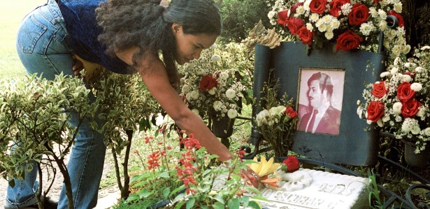 Mulher põe flores no túmulo de Pablo Escobar, em Medellin - Reuters