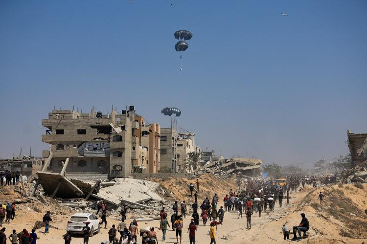 27.jul.2025 - Ajuda humanitária chega pelo meio aéreo em Gaza; população se aglomera em busca de comida