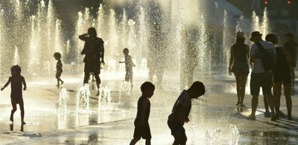 3.jul.2018 - Crianças brincam com fonte de água em Montreal, no Canadá - Eva Hambach/AFP