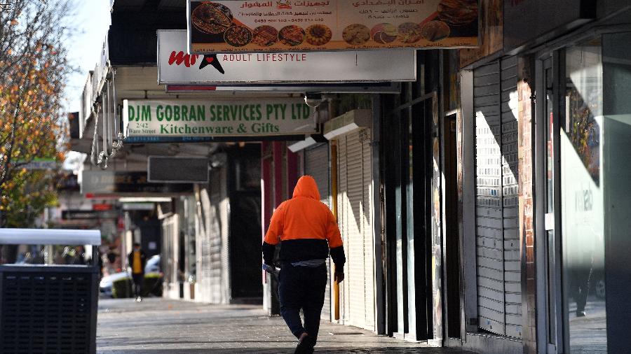 12.jul.2021 - Residente passa por lojas fechadas durante confinamento no subúrbio de Fairfield, em Sydney - Saeed Khan/AFP