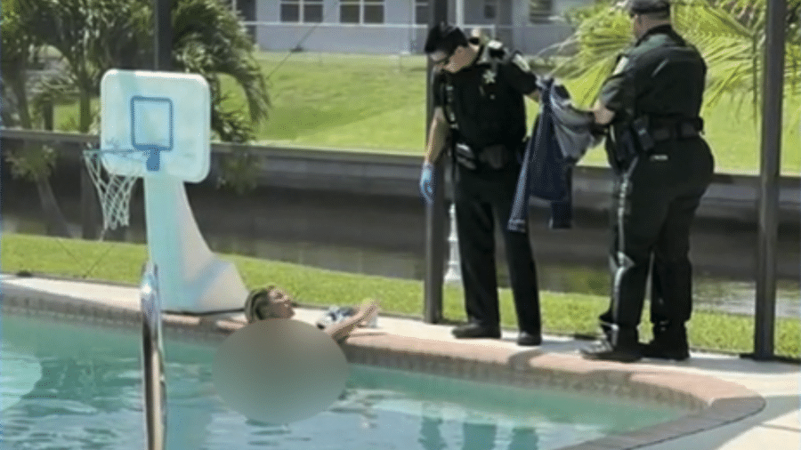 Mulher relaxa em piscina invadida enquanto policiais tentam tirá-la da água - Divulgação/Charlotte County Jail