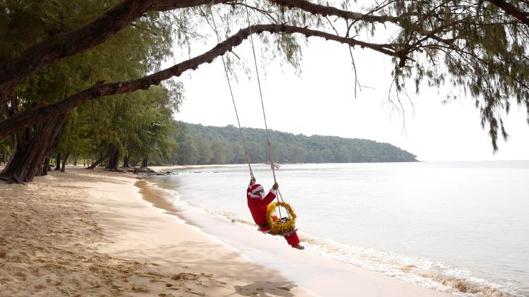 Papai Noel descansa em um balanço em Koh Russey, no Camboja, após atender os hóspedes de resorts locais. 