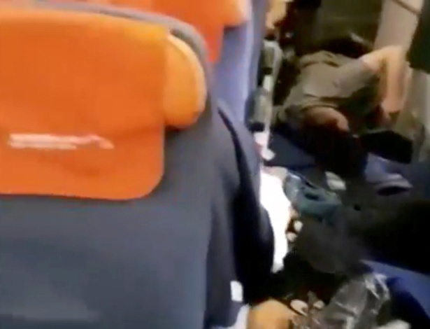 Imagem retirada de vídeo mostra passageiros deitando no chão do avião durante a turbulência - RR/Rostik Rusev/Divulgação via Reuters TV 