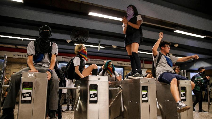2.dez.2019 - Manifestantes pulam catraca no metrô de Santiago, no Chile - JAVIER TORRES / AFP