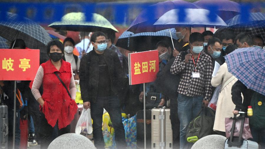 Chineses usando máscara em Macheng, em Hubei - Noel Celis / AFP
