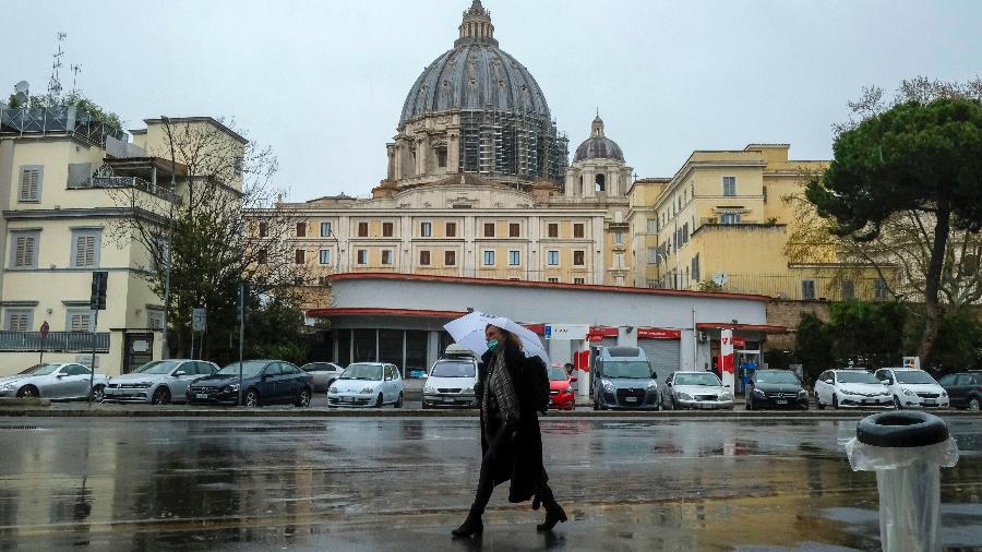 26.mar.2020 - Coronavírus: de máscara, mulher caminha próximo à Basílica de São Pedro, no Vaticano, Itália - Andreas Solaro/AFP