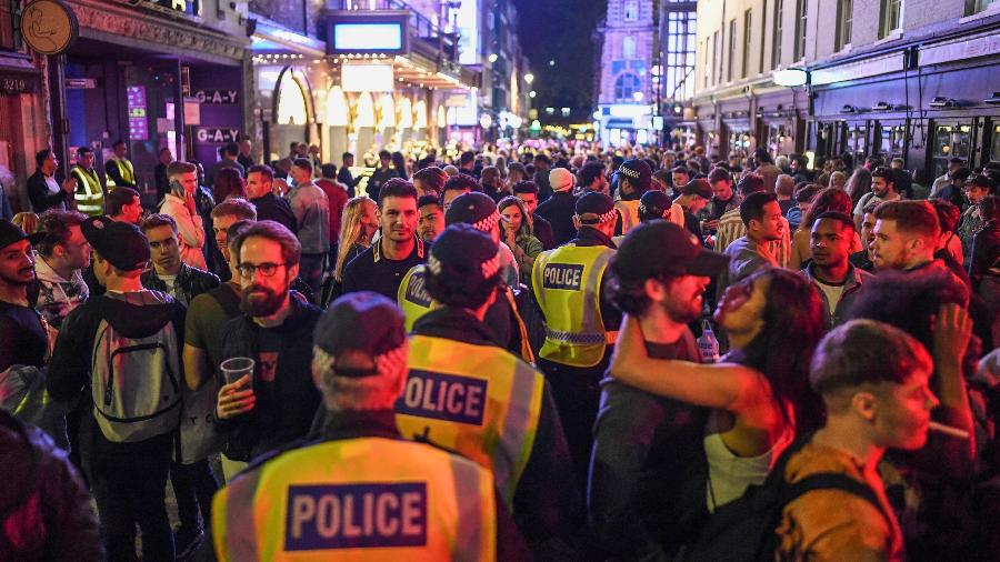Policiais andam em meio à aglomeração da reabertura dos bares no Soho, em Londres, após a pandemia de coronavírus - Getty Images