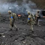 Militares ucranianos recolhem projéteis não detonados após confronto com russos, neste sábado (26) - Sergei Supinsky/AFP