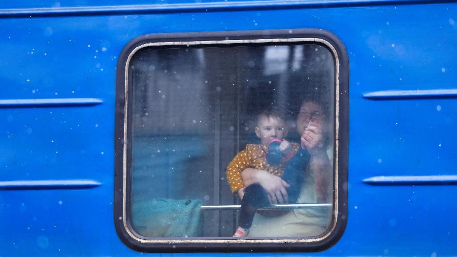 5.mar.2022 - Mulher e criança observam de um trem enquanto fogem da invasão russa da Ucrânia em direção à Polônia, na estação de trem em Lviv, na Ucrânia. - KAI PFAFFENBACH/REUTERS