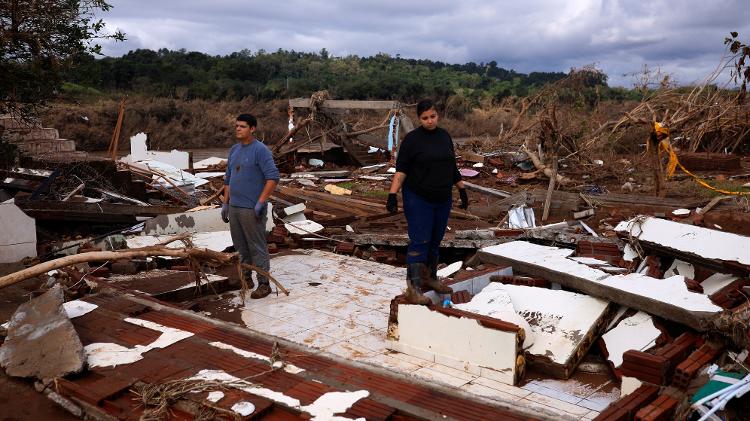 Jussara Wommer, 25, e seu marido Fernando Wommer, 20, sobre os escombros de sua casa destruída pelas enchentes do rio Taquari em Arroio do Meio (20/05).