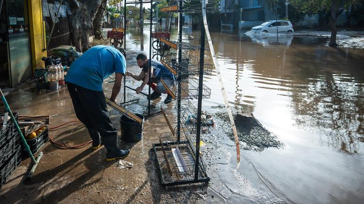 Comerciantes do bairro Menino Deus, em Porto Alegre, limpam loja depois de semanas de chuva intensa na capital