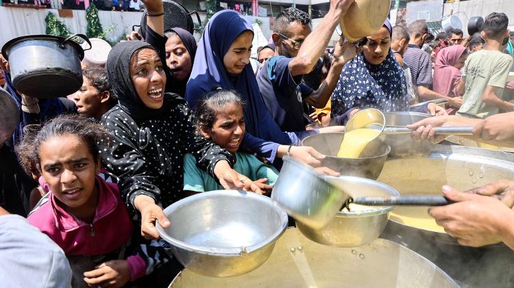 25.jul.2025 - Palestinos recebem sopa em ponto de distribuição de comida na Faixa de Gaza; centenas já morreram de fome por restrição imposta por Israel para ajuda humanitária 25.jul.2025 - Palestinos recebem sopa em ponto de distribuição de comida na Faixa de Gaza; centenas já morreram de fome por restrição imposta por Israel para ajuda humanitária