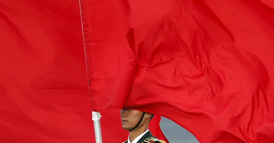 26.out.2015 - Bandeira encobre rosto de soldado, durante a cerimônia de boas vindas para o rei da Holanda Williem-Alexander, em Pequim, na China