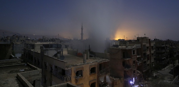 Fumaça sobe de prédios após bombardeio pelas forças sírias da área de Douma, controlada por rebeldes - Sameer al-Doumy/AFP