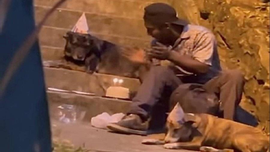 Imagem mostra o morador de rua José Luis Matos celebrando cantando parabéns para um dos seus cães - Reprodução/Redes Sociais