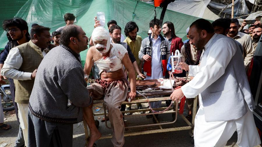 Civis ajudam no socorro a um ferido depois da explosão em mesquita de Peshawar, no Paquistão  - Khuram Parvez/Reuters