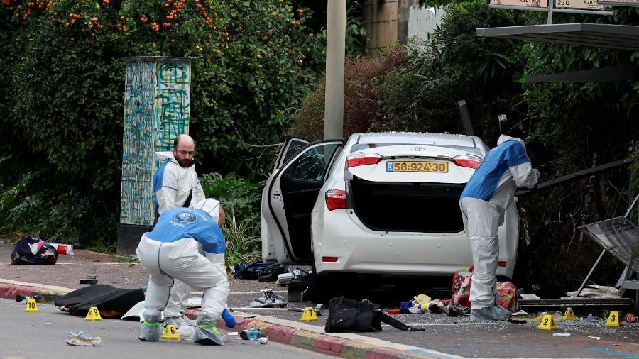 15.jan.24 - Pessoas trabalham ao lado de um veículo após um suposto ataque em Raanana, Israel