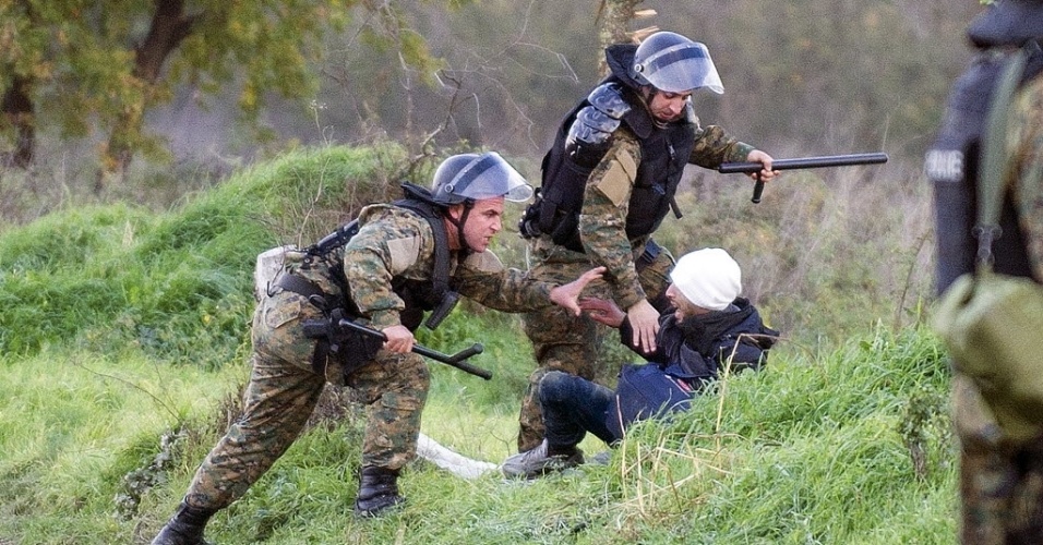 26.nov.2015 - Policiais macedônios agridem um imigrante na fronteira com a Grécia. Mais de 200 imigrantes tentaram romper as cercas de arame e atravessar da Grécia para a Macedônia, que impôs novas restrições nas fronteiras