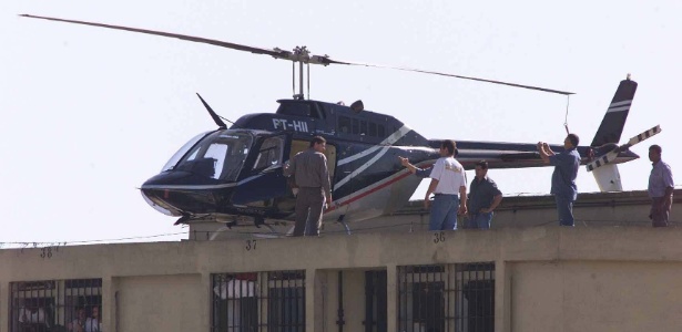 Técnicos verificam o estado de helicóptero usado na tentativa de resgate de presos na penitenciária de Adriano Marrey, em Guarulhos, em 2003 - Moacyr Lopes Junior/Folhapress - 3.jul.2003