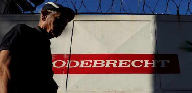 Homem passa por construção com o logo da Odebrecht em Caracas, na Venezuela - Carlos Garcia Rawlins/Reuters
