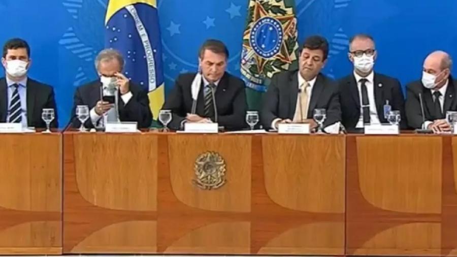 Bolsonaro, ao centro, coordena a coletiva midiática do tira-e-põe as máscaras. Era uma tentativa de sair do atoleiro político em que se meteu. Foi inútil - Reprodução