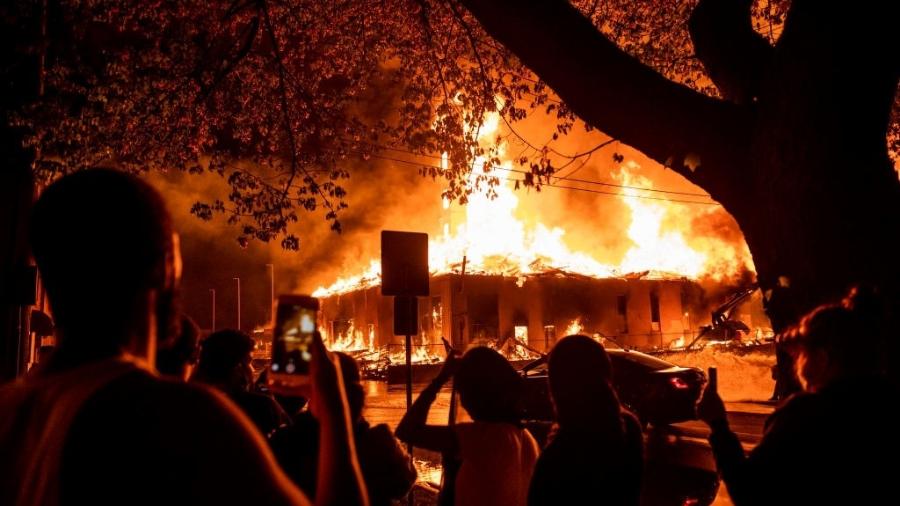 Manifestantes observam prédio em chamas durante protestos pela morte de George Floyd, em Minneapolis, nos EUA - Stephen Maturen/Getty Images
