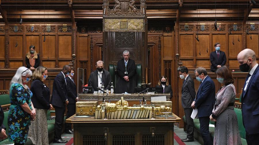 De máscara, membros do Parlamento britânico fazem um minuto de silêncio para lembrar um ano do primeiro lockdown - Jessica Taylor/AFP