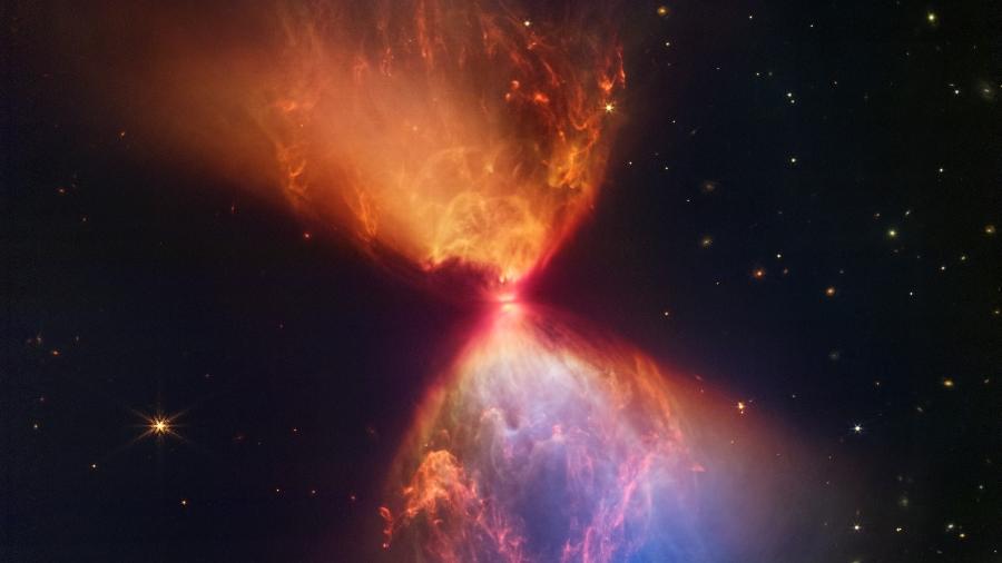 Imagem feita pelo telescópio James Webb mostra uma protoestrela dentro de uma nuvem escura; a imagem resultante lembra uma ampulheta - ESA, NASA, CSA, STScI / AFP