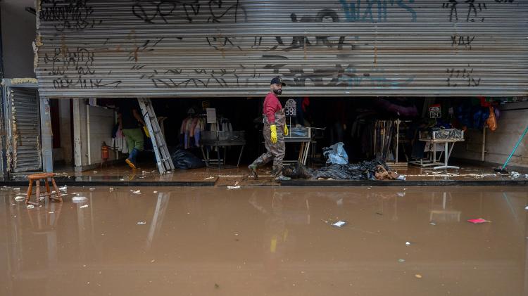 Lojistas do centro da capital seguem com a limpeza de comércios, na última segunda-feira (20), em ruas onde a água já baixou
