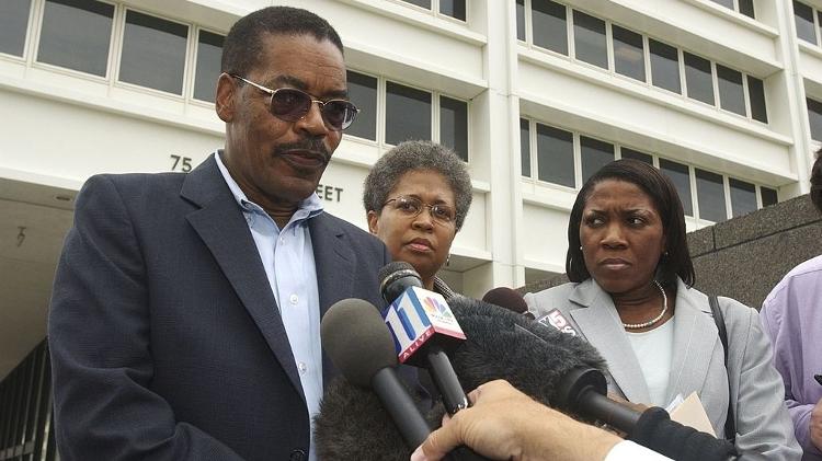 6 de julho de 2006 - George Williams fala em nome de sua filha, Joya Williams, assistente executiva do diretor de Marketing Global da Coca-Cola, acusada de roubar segredos comerciais, em frente ao Edifício Federal Richard Russell, enquanto a mãe de Joya, Karen Williams, ao centro, e a advogada Wanda Jackson ouvem, em Atlanta, Geórgia. 