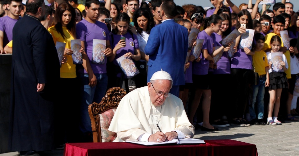25.jun.2016 - Papa Francisco assina livro de visitas de memorial que lembra as vítimas do genocídio na Armênia, no início do século XX, em seu segundo dia de viagem ao país asiático. O pontífice fez uma oração e colocou uma coroa de flores no local
