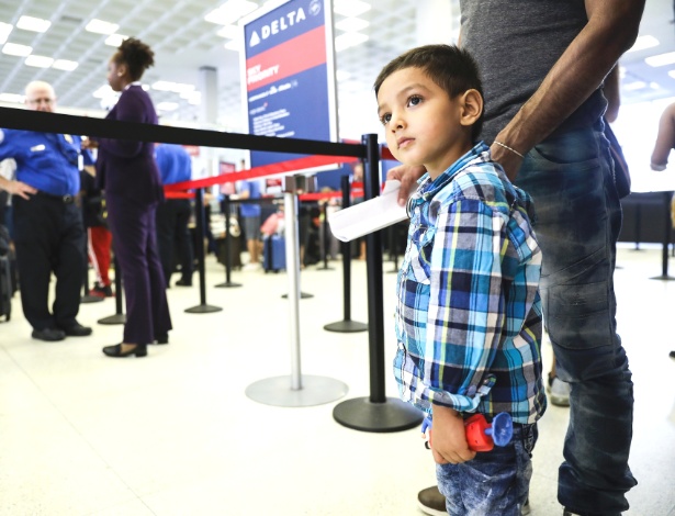 Denis Rivas e seu filho Joshua Rivas Chirino, 4, se reúnem no Aeroporto Internacional Kennedy, em Nova York - Marian Carrasquero/The New York Times
