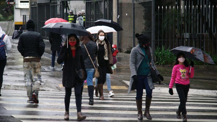 Pessoas se protegem do frio e da garoa no final da tarde na Avenida Paulista, em São Paulo, no final de agosto - Cris Faga/Estadão Conteúdo