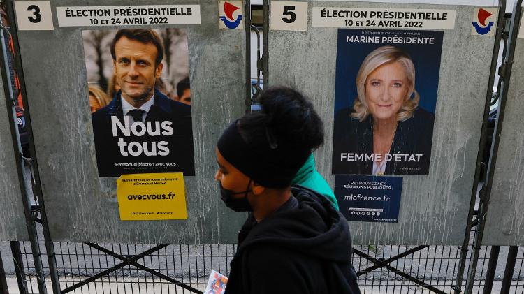 April 4, 2022 - People passing by the posters for the campaigns of Emmanuel Macron and Marine le Pen, who are candidates for the presidential elections in France, on display in the capital Paris - April 4, 2022 - Gonzalo Fuentes/Reuters - April 4, 2022 - Gonzalo Fuentes/Reuters