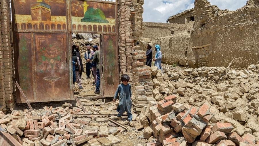 Criança anda em meio a destroços no Afeganistão; país foi atingido por terremoto no dia 22 de junho - AHMAD SAHEL ARMAN/AFP