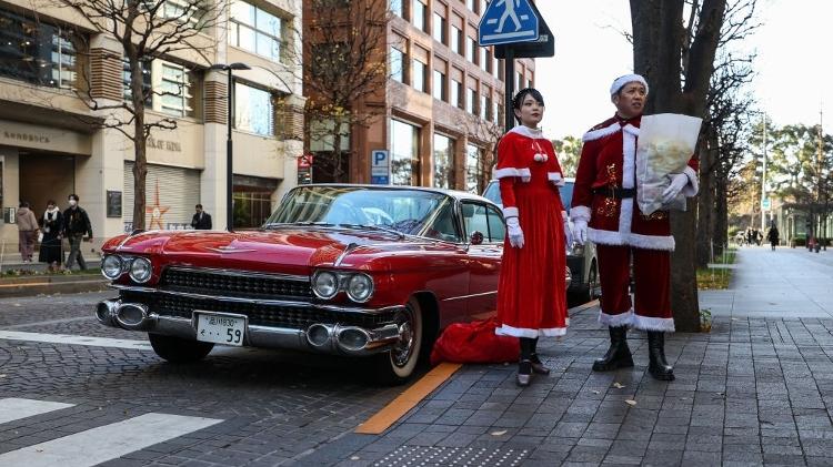 Hiroyuki Wada, dono de uma empresa de polimento em Tóquio, no Japão, e sua assistente Aco, distribuíram presentes para crianças vestidos a caráter para o Natal. 