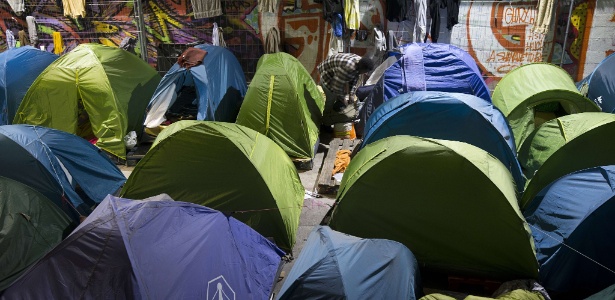 17.set.2015 - Imigrante reúne seus pertences para deixar campo de refugiados improvisado ao lado da estação de trem Austerlitz, em Paris - Joel Saget/AFP