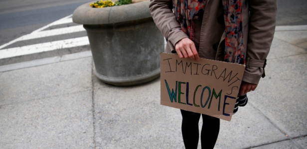 Manifestante segura cartaz em apoio a imigrantes durante protesto contra a nova medida do presidente Donald Trump para restringir a entrada de viajantes de países de maioria muçulmana nos EUA - Eric Thayer/ Reuters