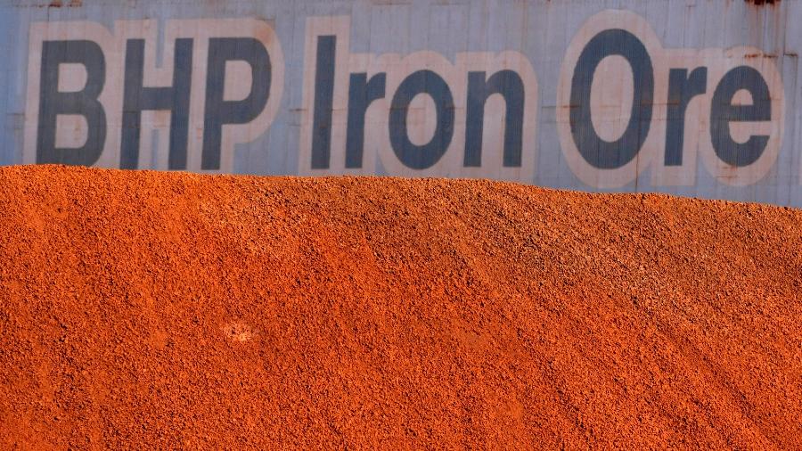 Logo da BHP em meio a pilha de minério de ferro em Port Hedland, Austrália - Tim Wimborne