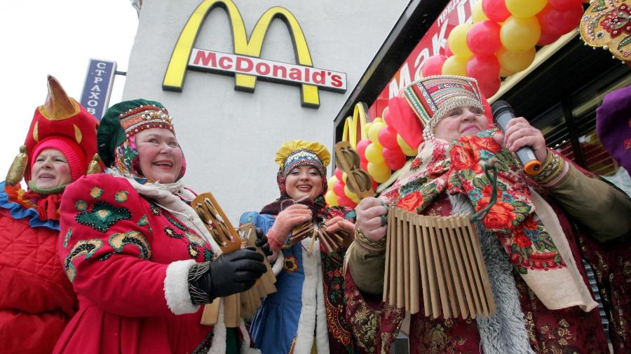 Músicos russos vestidos tradicionalmente se apresentam em frente ao restaurante McDonald"s mais movimentado do mundo na Praça Pushkin em Moscou - AFP
