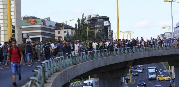 Centenas de imigrantes caminham em direção à fronteira austríaca, depois de deixarem a estação de trem de Budapeste, na Hungria - Bernadett Szabo/Reuters