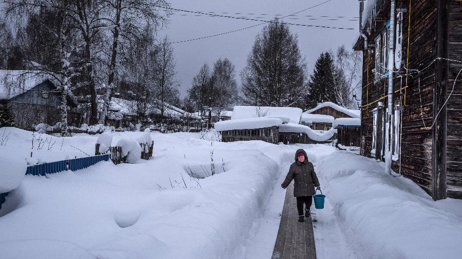 Mulher caminha durante dia frio na cidade de Urdoma, na Rússia - Sergey Ponomarev/The New York Times