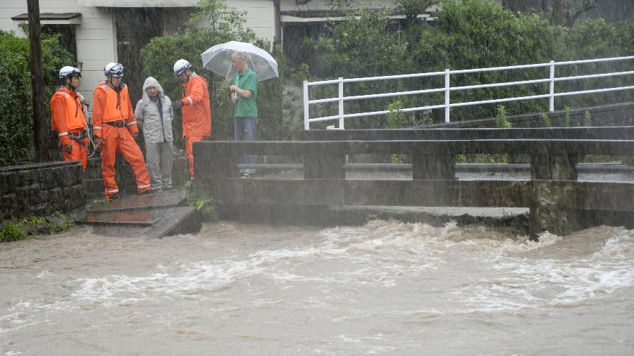 Equipes de resgate e moradores observam a subida do rio durante fortes chuvas em Kagoshima, no Japão - Kyodo/Reuters