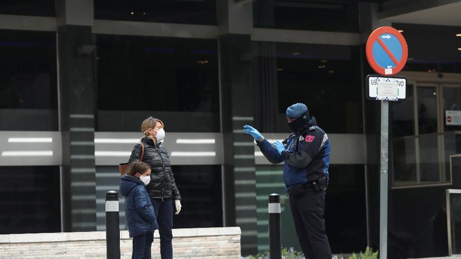 19.mar.2020 - Policial conversa com mulher do lado de fora de um hotel que foi criado para tratar pacientes não críticos com coronavírus - Susana Vera/Reuters