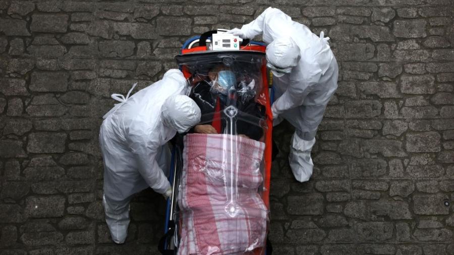 Médicos utilizam equipamentos de proteção enquanto transferem paciente infectado com o novo coronavírus em Seul, na Coreia do Sul - Chung Sung-Jun/Getty Images