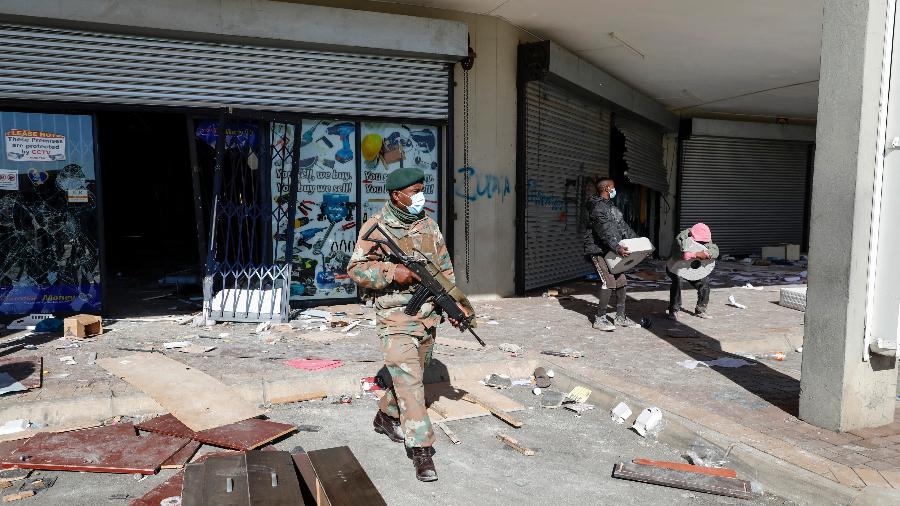13.jul.2021 - Membros da Força de Defesa da África do Sul patrulham a área saqueada de Diepkloof Square em Soweto, Joanesburgo - Phill Magakoe/AFP