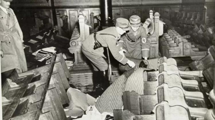 Nazi soldiers pouring gasoline on benches in a synagogue - YAD VASHEM - YAD VASHEM