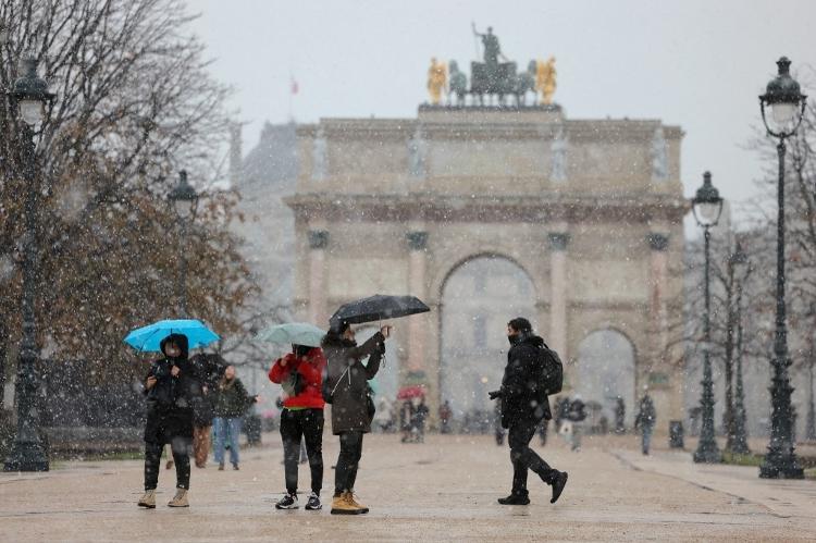 Turistas enfrentam neve para conhecer atrações em Paris